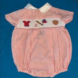 Red seersucker onesie with baseball detailing.